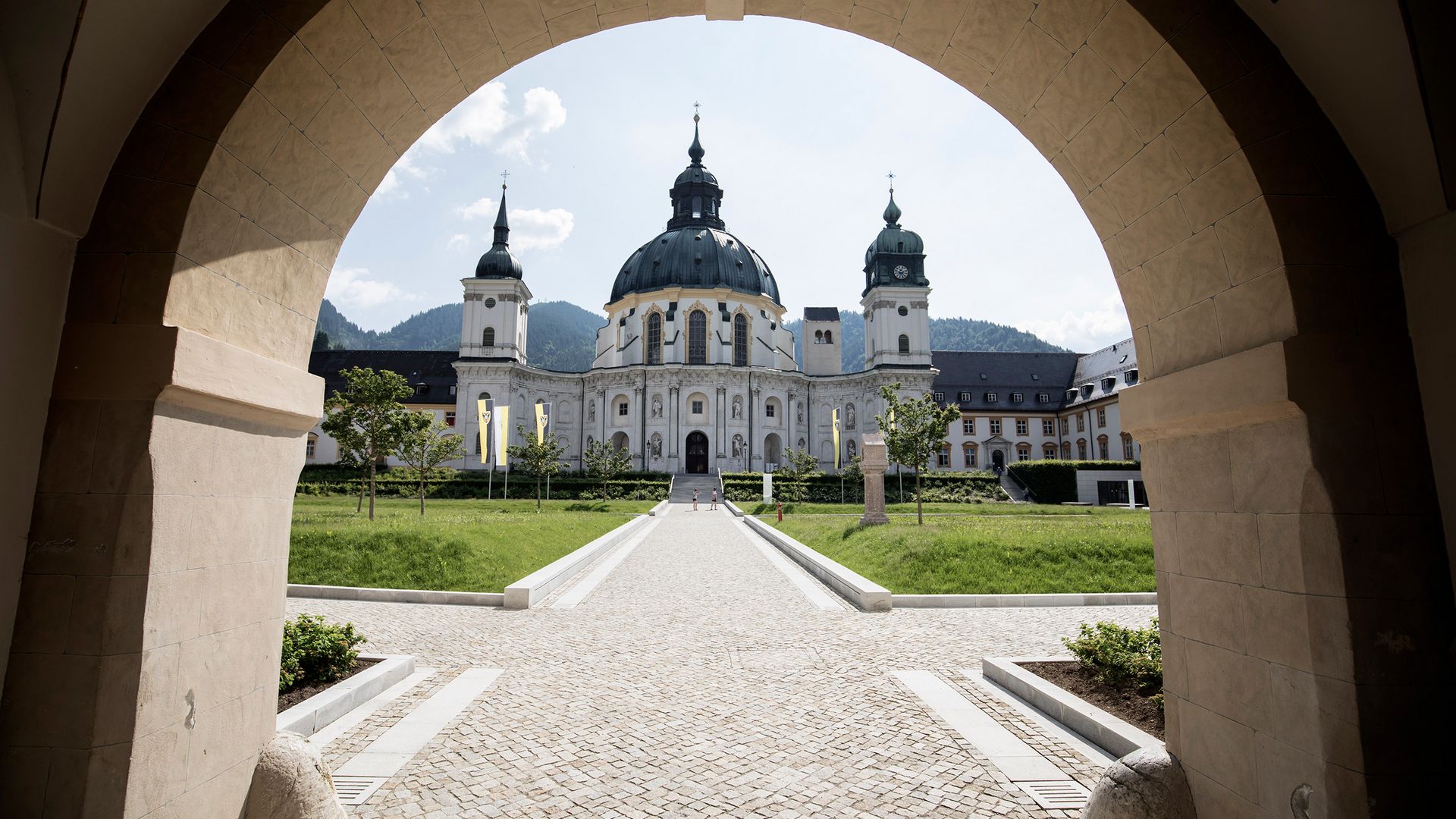 Die barocke Basilika des Kloster Ettal fotografiert durch den gegenüberliegenden Torbogen.